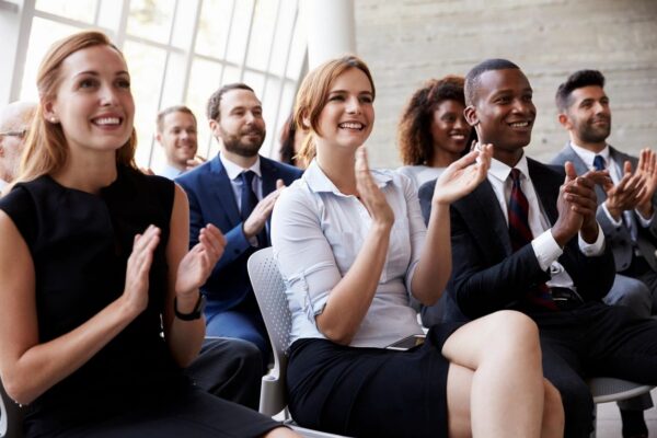 Adult students applauding at the end of a presentation.